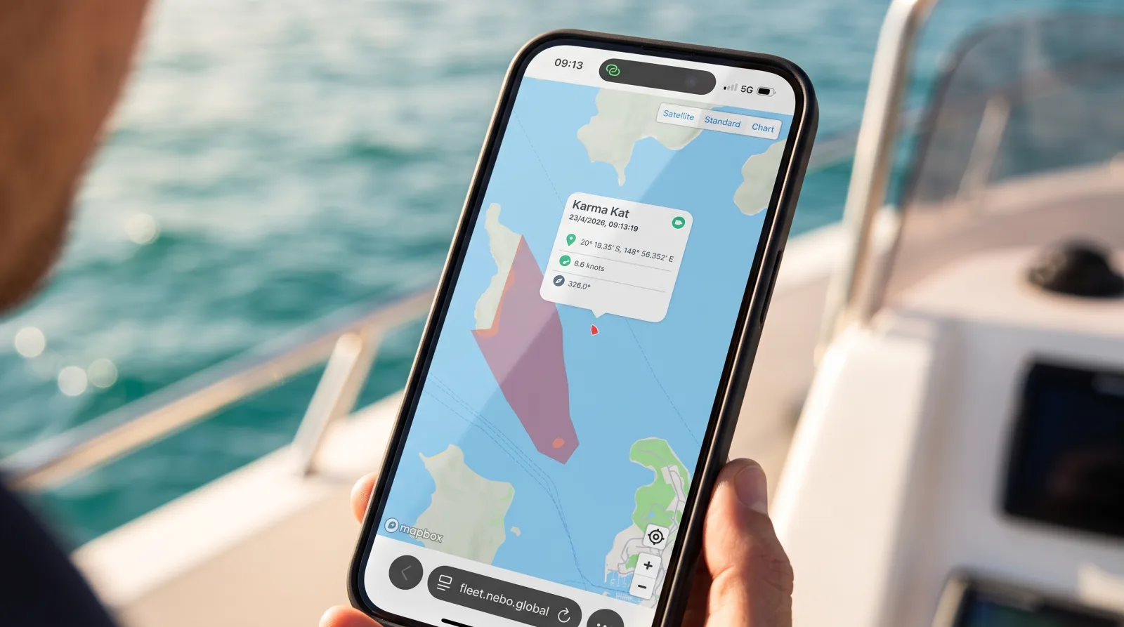 A guest on a boat viewing the Nebo Discovery map on their phone, showing a highlighted restricted area near the vessel