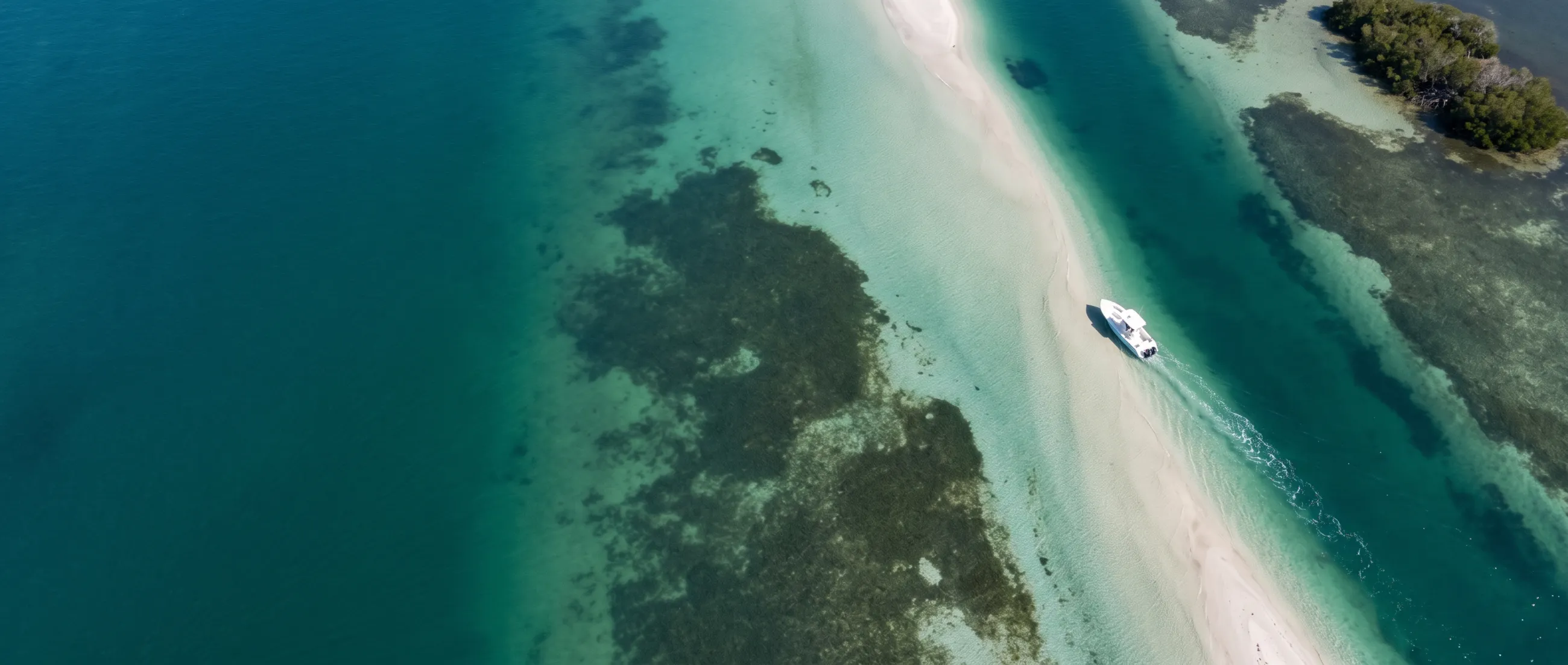 A club boat running along the edge of a sandbar, seen from above